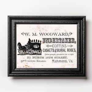 May include: Black framed vintage print featuring the text "W.M. Woodward, Undertaker" with an illustration of a horse-drawn hearse. The print also lists coffins, caskets, and burial robes. The address is 211 North 25th Street, Richmond, Va.