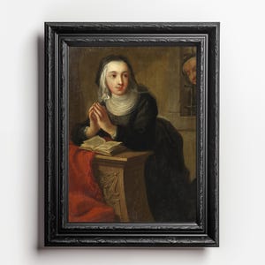 Puede incluir: Una pintura de una mujer con un vestido negro y una cubierta de cabeza blanca, rezando con las manos juntas. Está sentada en una mesa con un libro abierto frente a ella. La pintura está enmarcada en un marco negro.