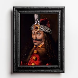 Könnte beinhalten: Ein gerahmtes Porträt eines Mannes mit dunklen Haaren und einem Schnurrbart, der eine rote und goldene Robe und einen mit Juwelen besetzten Kopfschmuck trägt. Der Hintergrund ist dunkelbraun.