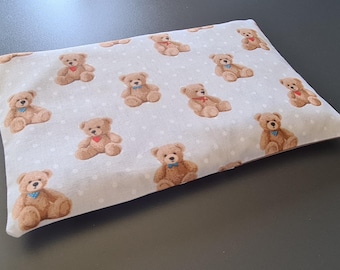 Heated pillow with washable outer cover. Relaxing pillow with teddy bear motif. Filled with cherry pits, rapeseed, and spelt grains, customizable with embroidery.