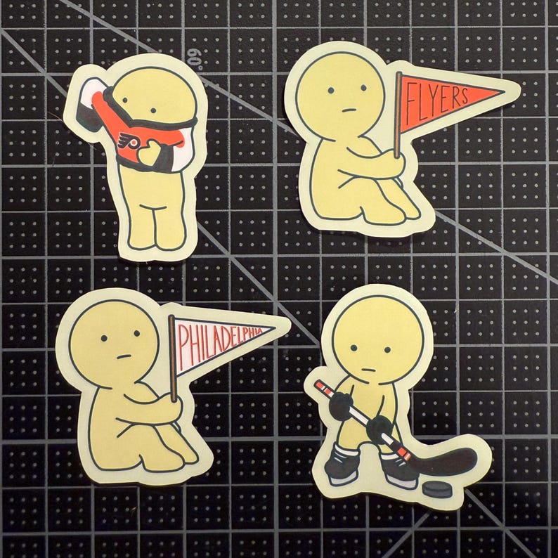 May include: Four die-cut stickers featuring a yellow cartoon character. One holds a Flyers jersey, one holds an orange Flyers pennant, one holds a white Philadelphia pennant, and one holds a hockey stick with a puck near black skates.