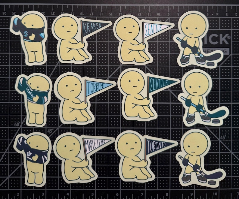 May include: A collection of twelve die-cut stickers featuring pale yellow cartoon figures. Some figures wear sports jerseys, some hold pennant flags labeled Kraken, Seattle, Torrent, Maple Leafs, or Toronto, and others hold hockey sticks with pucks.