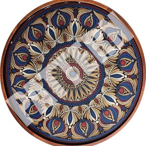 May include: A circular wooden tray featuring a detailed mandala pattern painted in shades of blue, beige, and deep red. The design consists of concentric rings of dots and petal-like shapes, all protected by a smooth, glossy, reflective finish.
