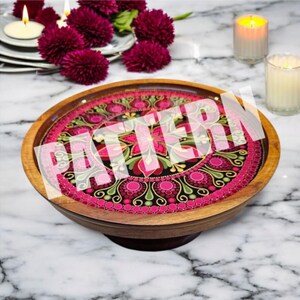 May include: A wooden serving tray with a vibrant, intricate floral pattern in pink, green, and black. The tray has a raised edge and a dark brown base. The word "PATTERN" is overlaid on the design.