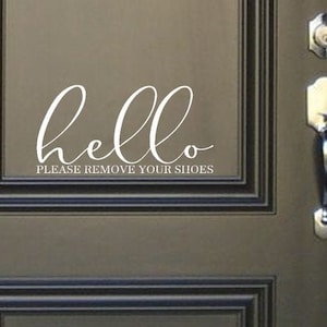 May include: A brown wooden door with a white vinyl decal that says "hello please remove your shoes".