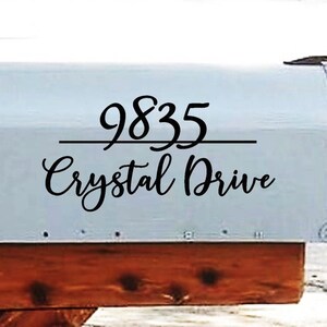 May include: A white mailbox with black lettering that reads "9835 Crystal Drive".