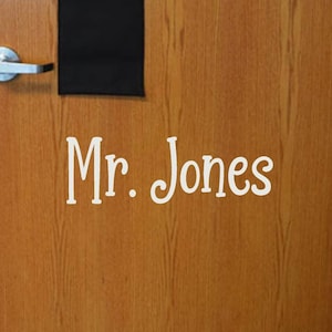 May include: A wooden door with a nameplate that reads "Mr. Jones".