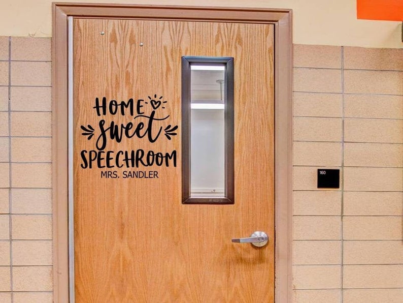 Puede incluir: Una puerta de madera con un letrero que dice "Home sweet speechroom Mrs. Sandler".