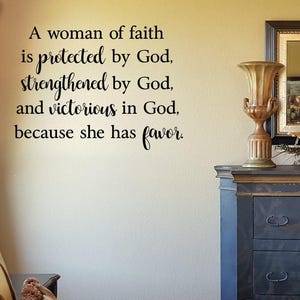 May include: A wall decal with a quote about faith: "A woman of faith is protected by God, strengthened by God, and victorious in God, because she has favor."