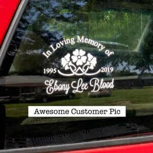 May include: White vinyl car sticker with the text "In Loving Memory of Ebony Lee Blood 1995 - 2019" and a floral design.