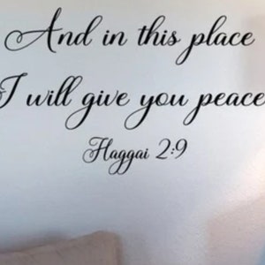 May include: Black and white typography wall decal with the quote "And in this place I will give you peace." and the scripture reference "Haggai 2:9".