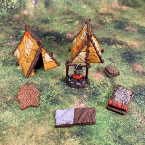 May include: A set of miniature, hand-painted, wooden teepees with a campfire and other accessories. The teepees are brown and yellow with white accents. The campfire is made of brown wood and has a black pot hanging from it. The accessories include a brown and white fur rug, a brown and white blanket, and a brown and white pillow.