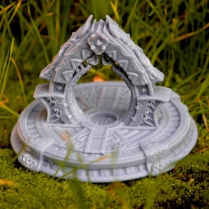 Può includere: Una miniatura stampata in 3D di colore grigio che rappresenta una piattaforma circolare con un arco a forma di drago. L'arco è decorato con sculture intricate e presenta un'apertura circolare al centro. La piattaforma è anche decorata con sculture intricate.