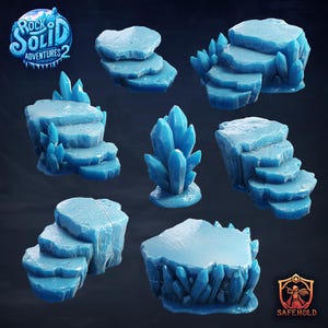 Könnte beinhalten: Eine Sammlung blau getönter Geländeteile für Tabletop-Spiele. Das Set enthält verschiedene Felsformationen, Stufen und Kristallcluster. Die Texte "Rock Solid Adventures 2" und "Safehold" sind sichtbar. Diese Teile sind für Fantasy-Rollenspiele konzipiert.