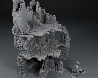 Op de afbeelding: Een grijze miniatuur van een verwoest stenen gebouw, met gedetailleerd metselwerk, houten balken en een kasseien basis. Een klein beeldje staat in de buurt, wat wijst op een tabletop game setting.