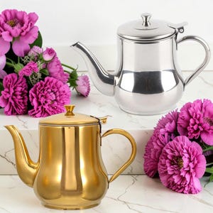 May include: A set of three ceramic mugs with a speckled, matte finish. The mugs are in shades of cream, light gray, and dark gray. Each mug has a simple, minimalist design, perfect for coffee or tea.