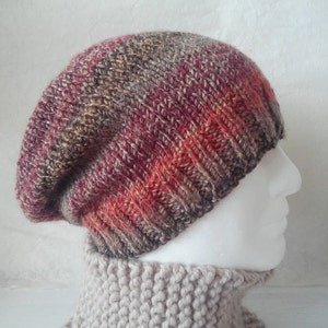 May include: A slouchy beanie hat with a red, brown, and gray color gradient. The hat is knitted with a textured stitch.
