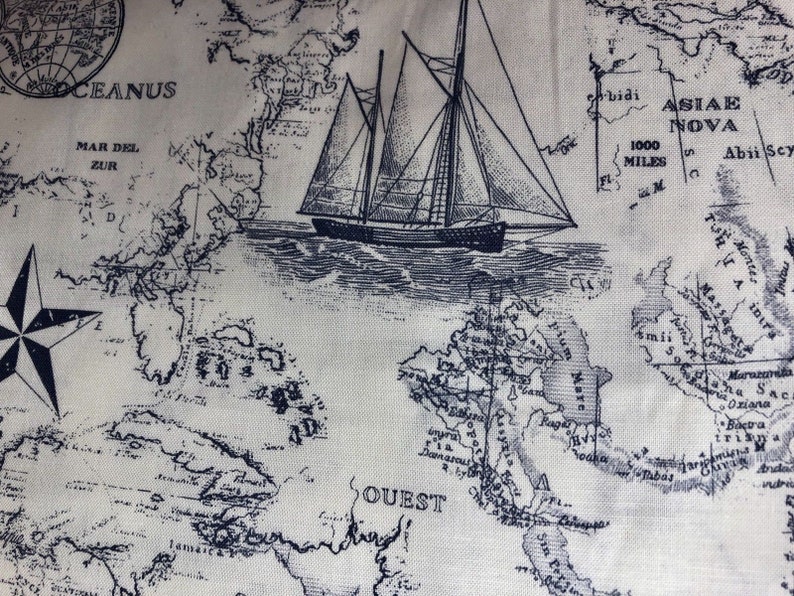 Pode incluir: Um tecido com uma estampa de mapa em estilo vintage em tinta azul escura sobre um fundo claro. O design inclui um veleiro detalhado, uma rosa dos ventos e v&aacute;rios r&oacute;tulos geogr&aacute;ficos como Oceanus, Mar Del Zur e Ouest.