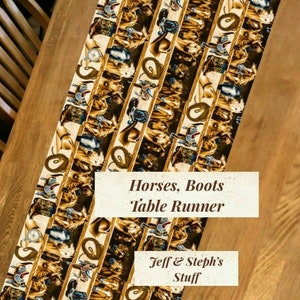 May include: A decorative table runner with a repeating pattern of horses, cowboy boots, and other western-themed imagery. The runner is primarily beige, brown, and tan, with accents of blue and red. The text "Horses, Boots Table Runner" is visible.