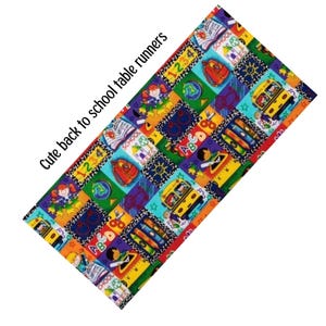 May include: A rectangular table runner featuring a colorful repeating pattern of school-themed illustrations including yellow buses, globes, crayons, backpacks, and the text "Cute back to school table runners" printed on the fabric surface.