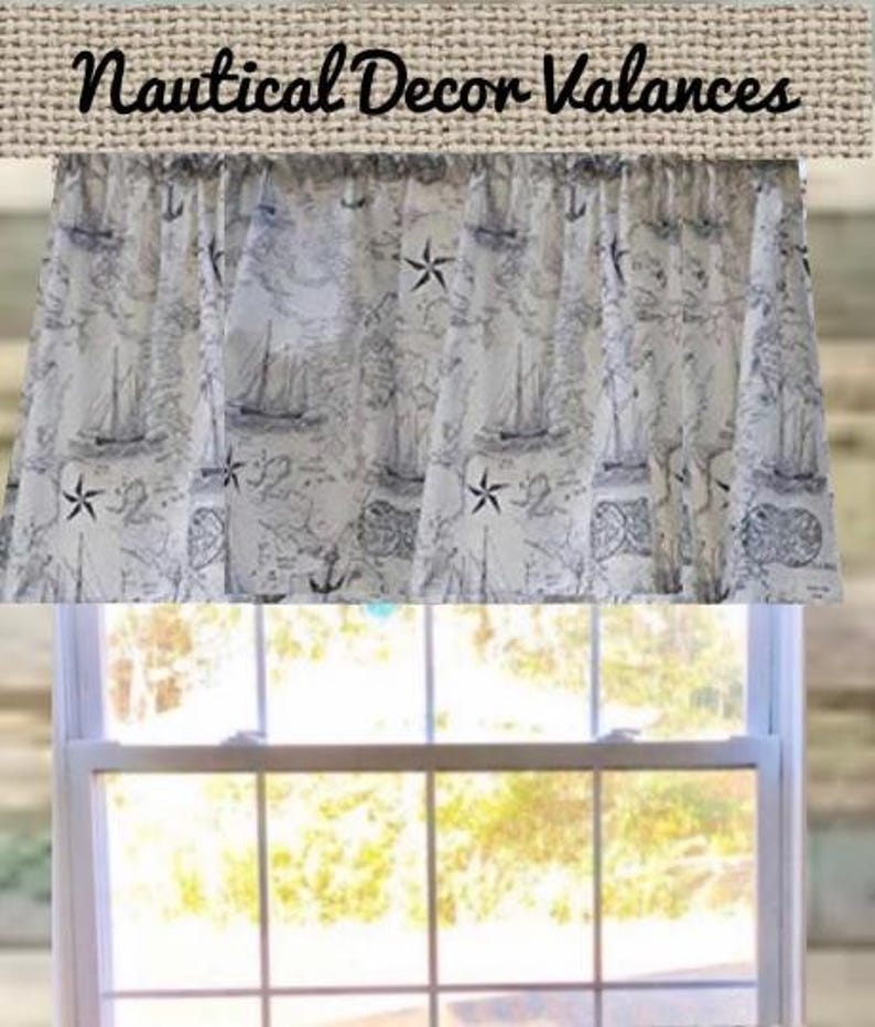 Pode incluir: Uma sanefa de janela com uma estampa n&aacute;utica apresentando ilustra&ccedil;&otilde;es em azul escuro de veleiros, &acirc;ncoras, b&uacute;ssolas e estrelas-do-mar sobre um fundo creme claro. O texto "Nautical Decor Valances" est&aacute; impresso em preto no topo.