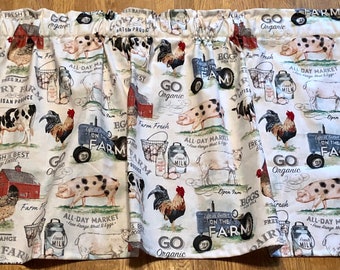 May include: A white fabric valance with a farmhouse theme. The valance features a repeating pattern of farm animals, including pigs, cows, chickens, and sheep. The valance also features text that says "Go Organic", "Farm Fresh", "Free Range", "Dairy Farm", and "All-Day Market".