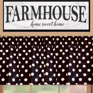 May include: A black and white polka dot valance hangs below a framed sign that reads "FARMHOUSE home sweet home". The valance is gathered and has large white polka dots. The sign is black and white with a farmhouse theme.