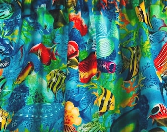 Könnte beinhalten: Lebhafter blauer Stoffvorhang mit einer farbenfrohen Unterwasserszene. Das Design zeigt verschiedene Fische in Gelb-, Rot- und Schwarztönen vor einem Hintergrund aus grünen Korallen und blauem Wasser. Der Vorhang ist oben gerafft.