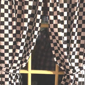 May include: Black and white checkered curtains hanging in a window. The curtains are made of a soft, fabric material and have a classic checkered pattern.