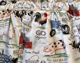 May include: Cream-colored fabric with a farm-themed print. The design includes illustrations of a rooster, cows, pigs, and a tractor, along with text such as "Farm Fresh" and "Eggs for Sale". The fabric has a gathered top.