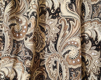 May include: A fabric featuring a dense paisley pattern in shades of black, cream, and tan. The intricate design consists of swirling teardrop shapes, floral motifs, and fine line work, creating a complex, repeating visual texture across the surface.