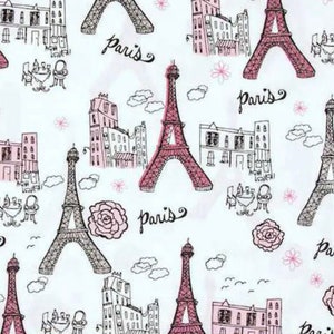 May include: White fabric with a repeating pattern of the Eiffel Tower, Parisian buildings, roses, and the word "Paris" in black script. The Eiffel Tower is depicted in both pink and black outlines.