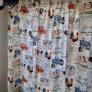 May include: A white fabric curtain with a repeating pattern of farm animals, including pigs, roosters, cows, and sheep. The pattern also includes farm-related items such as milk jugs, baskets, and tractors. The text "Go Organic" and "On the Farm" is repeated throughout the pattern.