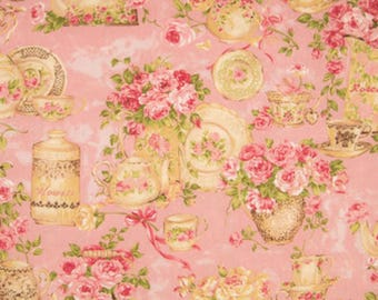 Può includere: Un tessuto rosa con un motivo ripetitivo di tazze da tè, teiere e rose. Il motivo è in tonalità di rosa, crema e marrone.