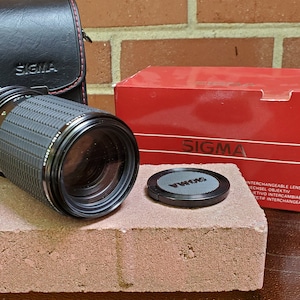 Sigma 80-200mm f/4.5-5.6 MF FD mount lens with case.