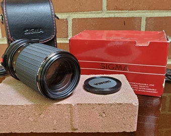 Sigma 80-200mm f/4.5-5.6 MF FD mount lens with case.