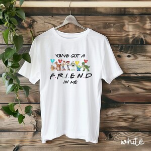 May include: White t-shirt with a graphic of Toy Story characters holding balloons and the text "You've got a friend in me."