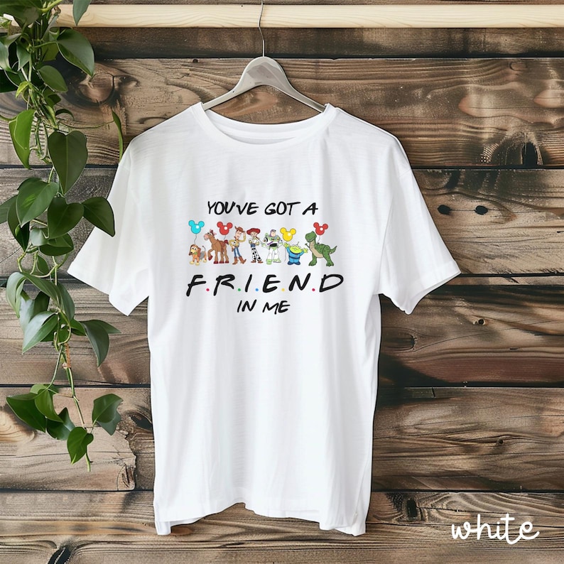 May include: White t-shirt with a graphic of Toy Story characters holding balloons and the text "You've got a friend in me."