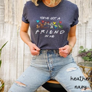 May include: A heather navy blue t-shirt with a graphic of Disney characters and the text "You've got a friend in me".