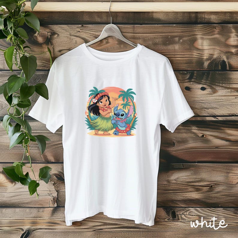 May include: White t-shirt featuring a colorful graphic of Lilo and Stitch in a tropical setting. The design includes palm trees, a sunset, and the characters in Hawaiian attire. The word "white" is printed at the bottom right.
