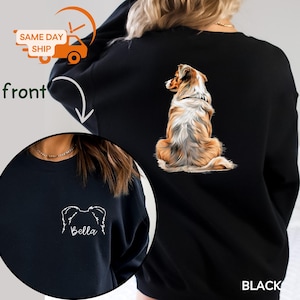 May include: Black sweatshirt with a detailed dog illustration on the back. The front displays a dog silhouette and the name "Bella". This casual sweatshirt is a comfortable style, perfect for everyday wear.