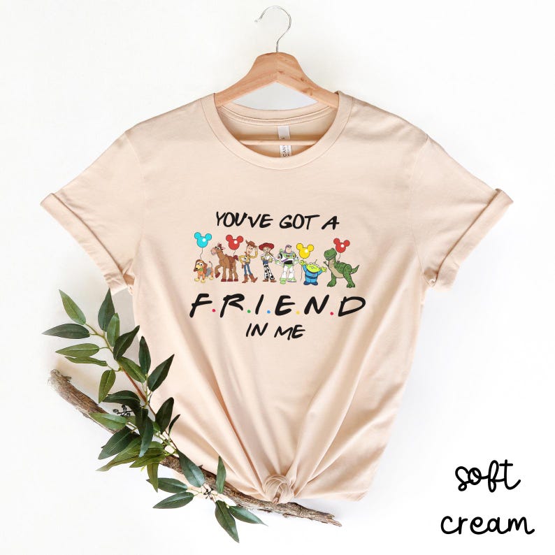 May include: A soft cream colored t-shirt with a graphic of Toy Story characters and the text "You've got a friend in me".