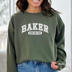 May include: A green sweatshirt with white text that reads "BAKER DIBS ON THE" in an arched font.