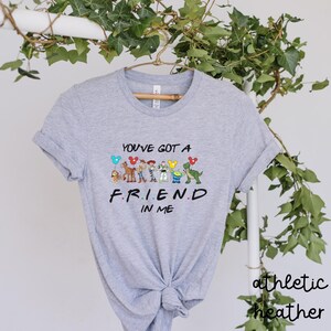 May include: A gray t-shirt with a graphic of the Toy Story characters and the text "You've got a friend in me".