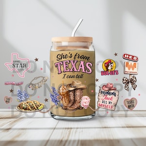 May include: A glass tumbler with a bamboo lid and straw featuring the text She's from TEXAS I can tell. The design includes illustrations of cowboy boots, a hat, tacos, bluebonnets, and Texas-themed logos like H-E-B, Whataburger, and Buc-ee's.