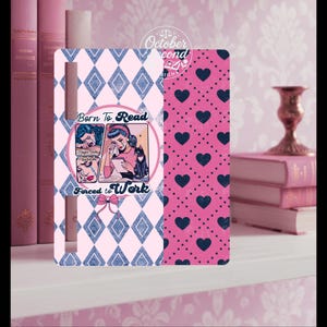 May include: A decorative phone case with a pink and blue diamond pattern and a pink heart pattern. The case features a retro comic-style illustration with the text "Born to Read, Forced to Work."