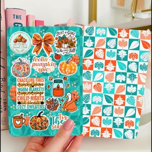 May include: A notebook with fall-themed stickers. The stickers feature pumpkins, leaves, bows, and phrases like "Just a Girl Who Loves Fall" and "Feelin' Pumpkin Spicy." The notebook's pages have a teal and orange leaf pattern.