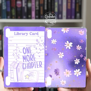 May include: A purple tablet case with a library card design and the text "ONE MORE CHAPTER." The other side features a purple floral design with white and pink flowers and gold glitter accents. The case is clear.
