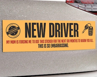 May include: A rectangular orange bumper sticker with black text reading "NEW DRIVER." Below, text states, "MY MOM IS FORCING ME TO USE THIS STICKER FOR THE NEXT SIX MONTHS TO WARN YOU ALL. THIS IS SO EMBARRASSING." A key and car remote graphic is on the right.