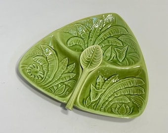 May include: A green ceramic serving dish shaped like a leaf with three sections and a matching spoon. The dish is decorated with a raised design of banana leaves.